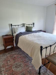 a bedroom with a large bed with a rug at Greenhills Guesthouse in Victor Harbor