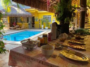 una mesa con comida junto a una piscina en Morada do Aventureiro, en Angra dos Reis