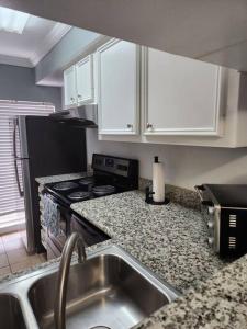 a kitchen with a sink and a stove top oven at Blue Shark *E10* @ Midtown Vibrant King Studio in Houston