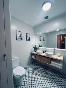 a bathroom with a toilet and two sinks and a mirror at Apartamento Crismar in Ronda +14 photos