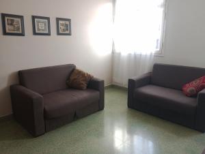 ein Wohnzimmer mit 2 Stühlen und einem Sofa in der Unterkunft Independencia 734, Dpto 11 in San Salvador de Jujuy