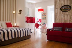 a bedroom with a bed and a red couch at Porto Náutico - City Centre in Porto