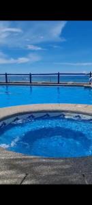 een groot zwembad van blauw water naast de oceaan bij Hospedaje Pirata Express in Capurganá