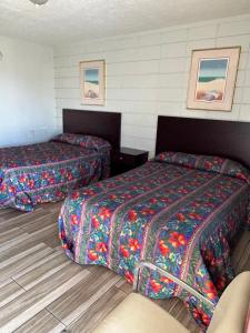 ein Hotelzimmer mit 2 Betten und bunten Decken in der Unterkunft Candlelight Inn in St Petersburg