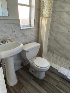 ein Bad mit einem WC, einem Waschbecken und einer Dusche in der Unterkunft Candlelight Inn in St Petersburg