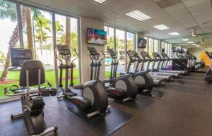 un gimnasio con filas de cintas de correr y bicicletas estáticas en Sunny Isles Condo Resort, en Miami Beach