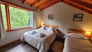 um quarto com 2 camas e uma janela em Bellavista em Villa La Angostura