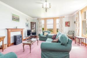 a living room with a person laying on a couch at Bramble Knowe, farm cottage near St Andrews in Dunino