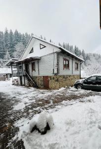 a house with snow in front of it at Sadyba Dana in Tatariv