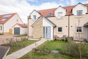 a bedroom house with a garden and a driveway at Pitmilly Park - 3 Beds - Garden in Kingsbarns