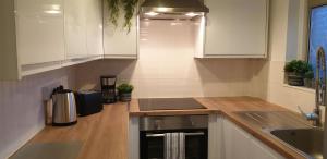 Una cocina con gabinetes blancos y un fregadero. en Comfort Stay Rooms, en Portslade-by-Sea 18 fotos más