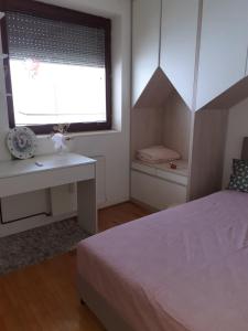 皮羅特的住宿－Aleksandar，一间卧室配有一张床、一张书桌和一个窗户。