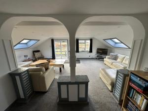 a living room with skylights and couches at Self Catering Spacious open plan 3 bed apartment with sea views in South Erradale
