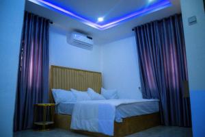 a bedroom with a bed with purple lights on it at Still_homes apartment in Kubwa