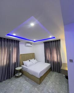 a bedroom with a large bed with a blue ceiling at Still_homes apartment in Kubwa