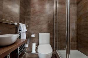 a bathroom with a toilet and a sink and a shower at Pipeland Loft in St. Andrews