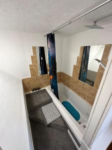 La salle de bains est pourvue d'un escalier avec une baignoire et un miroir. dans l'établissement Self Catering Spacious open plan 3 bed apartment with sea views, à South Erradale