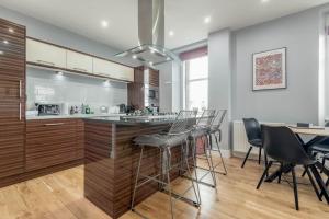 a kitchen with a bar with chairs and a table at Pipeland Loft in St. Andrews +9 photos