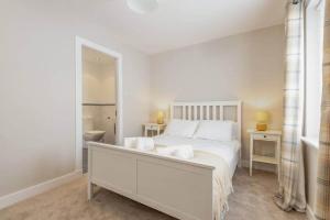 a white bedroom with a bed and a bathroom at 14 Southfield - 3 Bed/2 Bath - Parking in St. Andrews