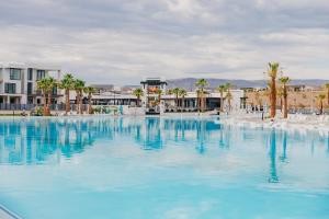 ein großer Pool mit blauem Wasser mit Palmen und Gebäuden in der Unterkunft Anchor Oasis #87 condo in St. George