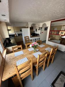 a dining room table with chairs and a kitchen at Self Catering Spacious open plan 3 bed apartment with sea views in South Erradale