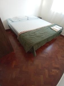 Bett in einem Zimmer mit Holzboden in der Unterkunft Independencia 734, Dpto 11 in San Salvador de Jujuy