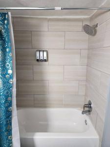 a bathroom with a white tub and a sink at Blue Shark *B542* @ Medical Center Modern 1BR King Apartment in Houston