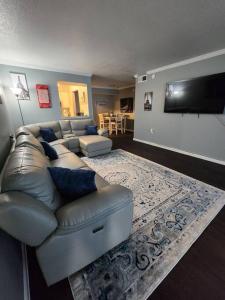 a living room with a leather couch and a flat screen tv at Blue Shark *B542* @ Medical Center Modern 1BR King Apartment in Houston