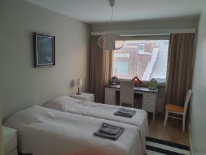 Schlafzimmer mit einem Bett, einem Schreibtisch und einem Fenster in der Unterkunft Rovaniemi city Apartment in Rovaniemi