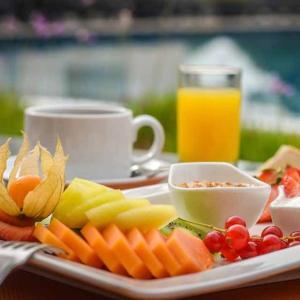a tray of fruit and vegetables on a table with a cup of juice at El Remanso Complejo Ecoturistico 