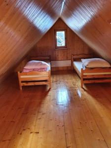 una stanza con due letti in una cabina di legno di Domek Biała Dolina a Szklarska Poręba