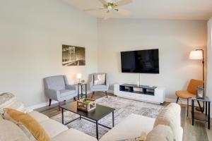 uma sala de estar com um sofá e uma televisão de ecrã plano em Bright Little Chute Condo with Deck and Yard! em Little Chute