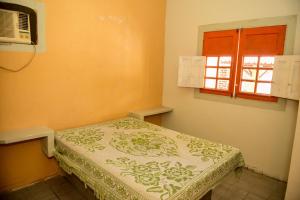 a small room with a bed with a window at Excelente casa c lazer prox a praia Tamandare PE in Tamandaré