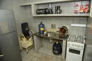 a small kitchen with a sink and a stove at Excelente casa c lazer prox a praia Tamandare PE in Tamandaré