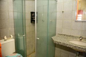 a bathroom with a glass shower with a toilet and a sink at Excelente casa c lazer prox a praia Tamandare PE in Tamandaré +14 photos