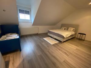 a attic bedroom with two beds and a wooden floor at Modernes Haus in Parndorf in Parndorf