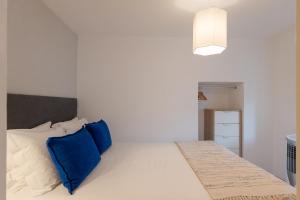 - une chambre avec un lit blanc et des oreillers bleus dans l'établissement Contemporary Apartment in Chiado 3, à Lisbonne