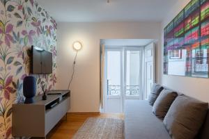 - un salon avec un canapé et une télévision dans l'établissement Contemporary Apartment in Chiado 3, à Lisbonne