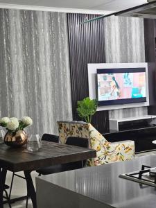 - un salon avec une table et une télévision dans l'établissement Luxie@92, à Midrand