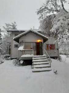 una casa con nieve en el suelo delante de ella en Garden Caravan, en Rovaniemi