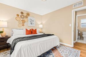 een slaapkamer met een groot wit bed met oranje kussens bij New! Beautiful 1BR in Sharon Lane in Roseville