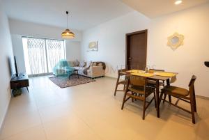 una sala da pranzo e un soggiorno con tavolo e sedie. di Cozy 1 Bedroom In Gate Tower a Abu Dhabi