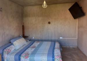 a bedroom with a bed with a quilt on it at Rincón "MIS SOLES" in Maipú