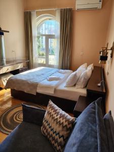 a bedroom with a large bed and a window at Riverside Baratashvili Apartment in Tbilisi City