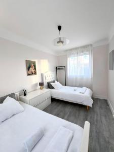 a white bedroom with two beds and a couch at Maison Entier JO 2024 Clim Disney 2 rooms in Gournay-sur-Marne