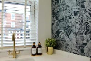 a kitchen sink with three bottles of wine on a counter at Clement House, York, Free EV and parking in York