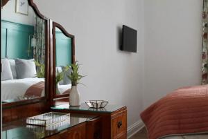 a bedroom with a bed and a mirror and a table at Clement House, York, Free EV and parking in York