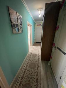 un pasillo con paredes azules y una alfombra en el suelo en House near airport ЖК ЮГ en Prigorodnyy