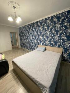 1 dormitorio con 1 cama con papel pintado azul y blanco en House near airport ЖК ЮГ en Prigorodnyy