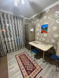 uma sala de jantar com uma mesa e cadeiras azuis em House near airport ЖК ЮГ em Prigorodnyy